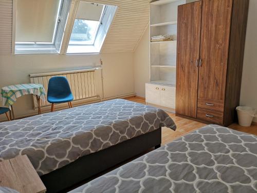 a bedroom with a bed and a chair and a window at Family room for 4-6 person in Budapest