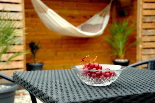 un cuenco de cerezas en una mesa con una hamaca en Bakkely GuestHouse en Randers