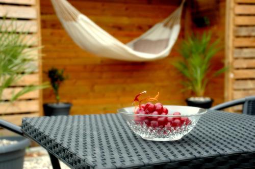 a bowl of cherries on a table with a hammock at Bakkely GuestHouse in Randers