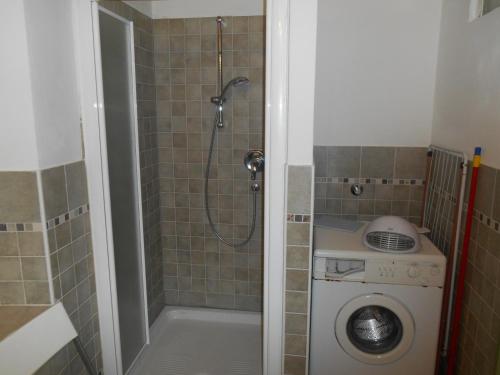 a bathroom with a shower and a washing machine at CASA CAMPAGNA in Cavalese