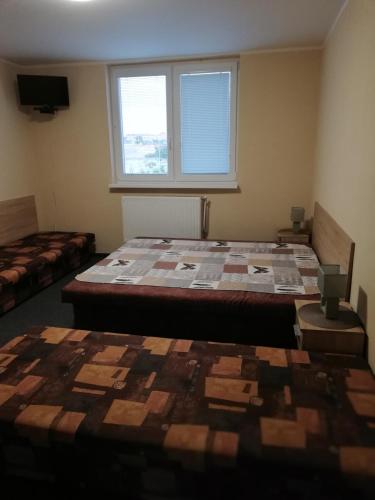 a room with two beds and a window at CENTRO in Štúrovo