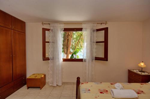 ein Schlafzimmer mit einem Bett und einem Fenster in der Unterkunft Alexandra Studios 2 in Alonnisos Altstadt