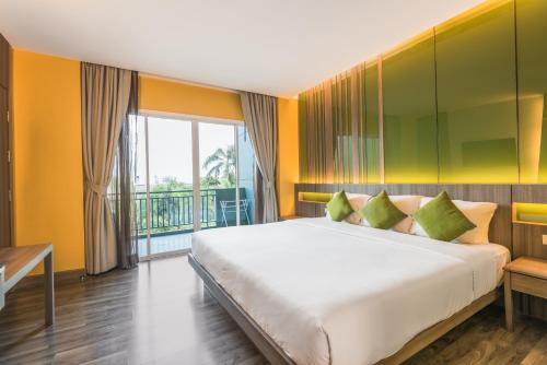 a bedroom with a large bed and a balcony at Lantana Pattaya - SHA Extra Plus in Pattaya North