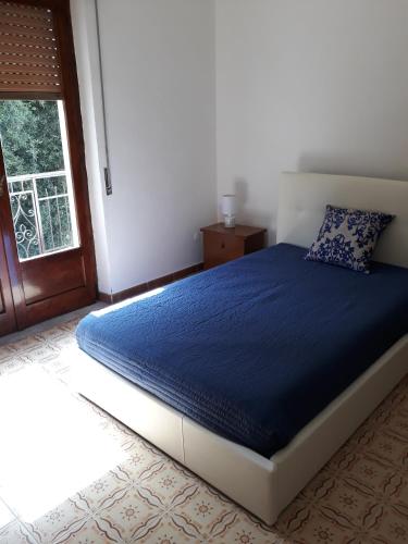 een slaapkamer met een bed met een blauw dekbed bij Casa MARINA in Policastro Bussentino