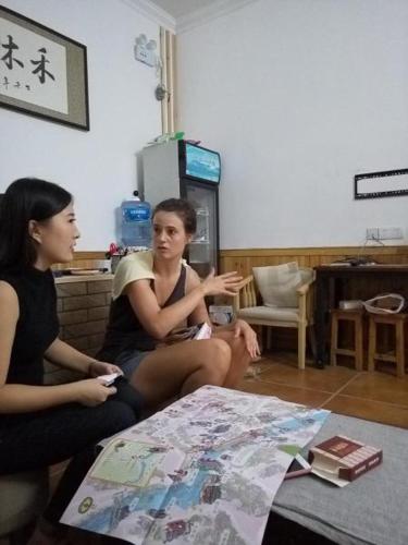 two women sitting on the floor in a room at Hemu House in Fenghuang