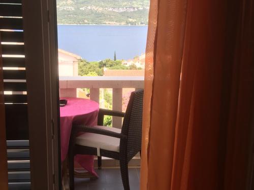 a balcony with a table and chairs and a view of the water at Anamarija's Apartments in Korčula