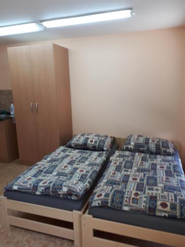 a bedroom with two beds and a cabinet at U Seckých in Rakvice