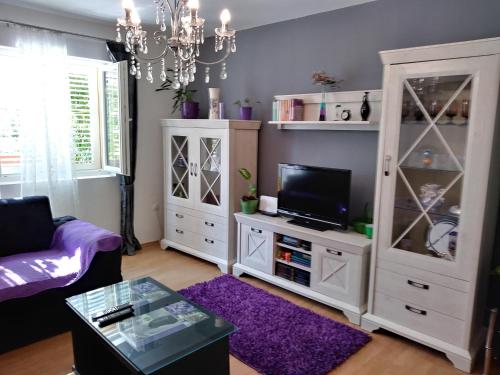 ein Wohnzimmer mit einem TV und einem weißen Schrank in der Unterkunft Apartments Mira in Biograd na Moru