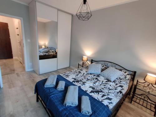 a bedroom with a blue and white bed with pillows at Mazurski Apartament in Mrągowo