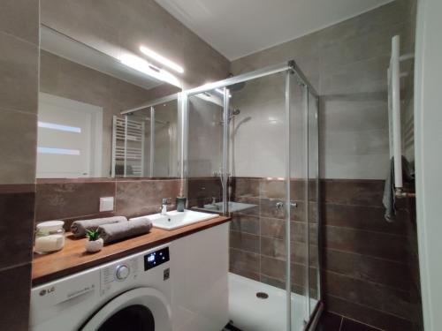 a bathroom with a washing machine and a shower at Mazurski Apartament in Mrągowo