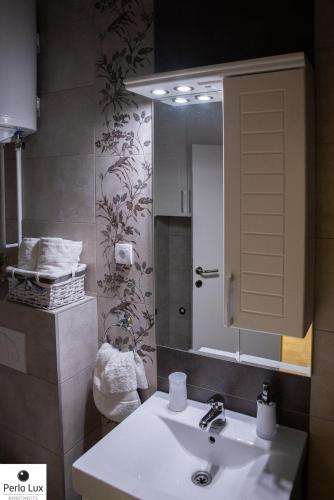 a bathroom with a sink and a mirror at Perla Lux Apartments in Arandjelovac