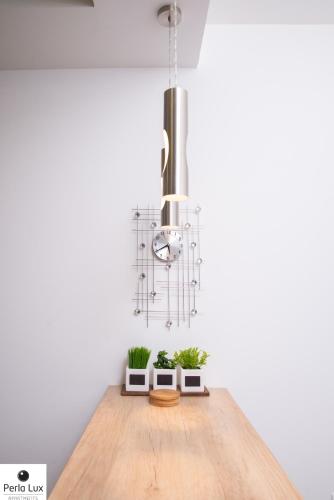 a chandelier hanging over a wooden table with potted plants at Perla Lux Apartments in Arandjelovac