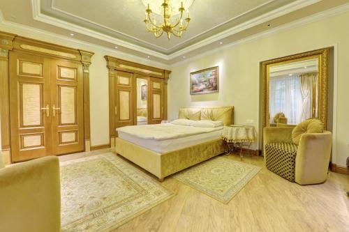 a bedroom with a bed and two chairs and a chandelier at Luxury Pilies Avenue Apartment in Vilnius