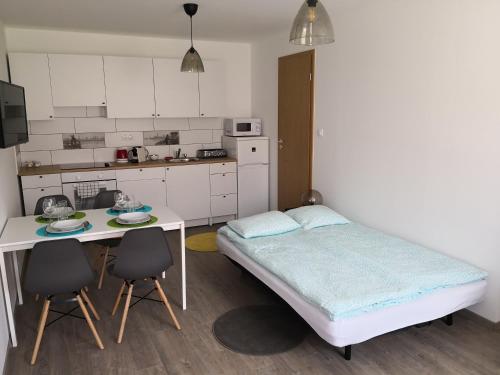 sypialnia z łóżkiem, stołem i krzesłami w obiekcie Green Garden Plus Apartman w Budapeszcie