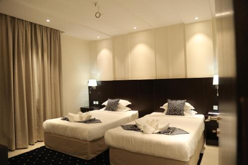 a hotel room with two beds with white sheets at Lamar Al Bawadi Hotel in Jeddah
