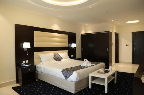 a hotel room with a large bed and a table at Lamar Al Bawadi Hotel in Jeddah