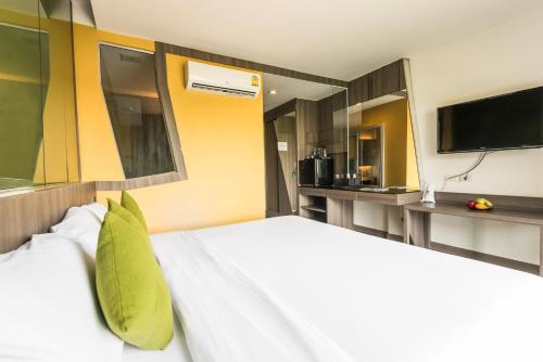 a bedroom with a large bed with a tv on the wall at Lantana Pattaya - SHA Extra Plus in Pattaya North