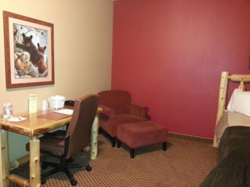 a room with a desk and chairs and a bed at The Lodge at Brainerd Lakes, Trademark Collection by Wyndham in Baxter