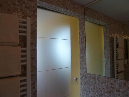 a sliding door in a bathroom with a mirror at Forster's Nest in Cannero Riviera