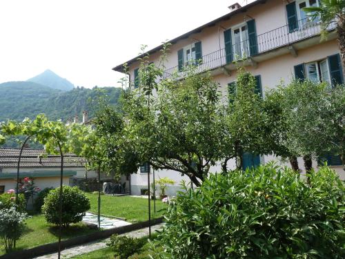 a building with trees in front of a yard at Forster's Nest in Cannero Riviera