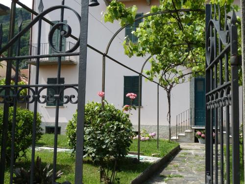 a gate in front of a house with pink flowers at Forster's Nest in Cannero Riviera