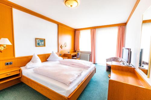 1 dormitorio con 1 cama, escritorio y TV en Gasthof Pension Post en Denkendorf