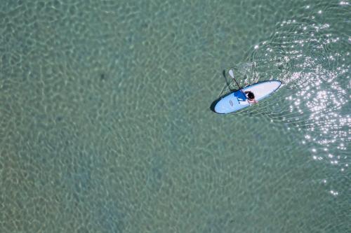 a person on a surfboard in the water at Bohemian Luxury Boutique Hotel, Adults Only in Naousa