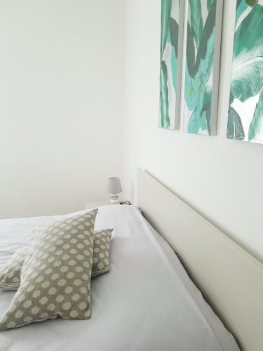 a white bed with two pillows next to a window at Poggio di Pastrengo in Pastrengo