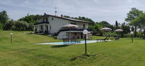 a house on a hill with a pool in the grass at Poggio di Pastrengo in Pastrengo