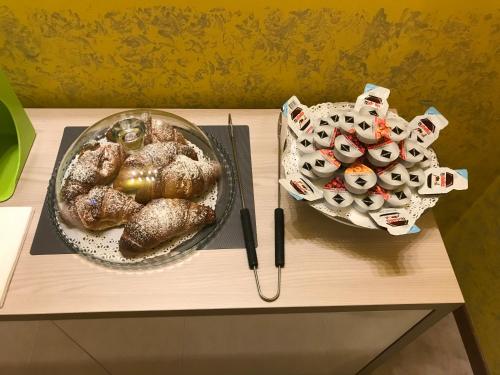 a table with a plate of food and a bowl of cookies at B&B IL VIALETTO in Orio al Serio