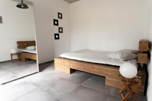 1 dormitorio con cama y espejo en L'appartement en Reconvilier