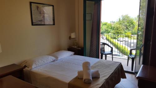 a bedroom with a bed and a balcony with a view at Casa Betania in Pisa