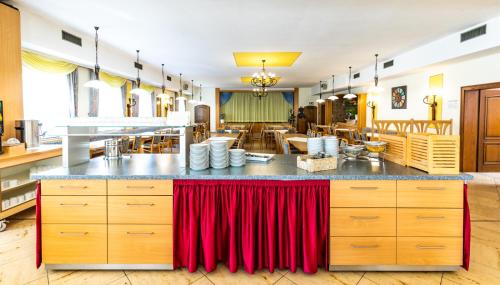 Gasthof Pension Post في دنكندورف: مطبخ به طاولة عليها ستائر حمراء