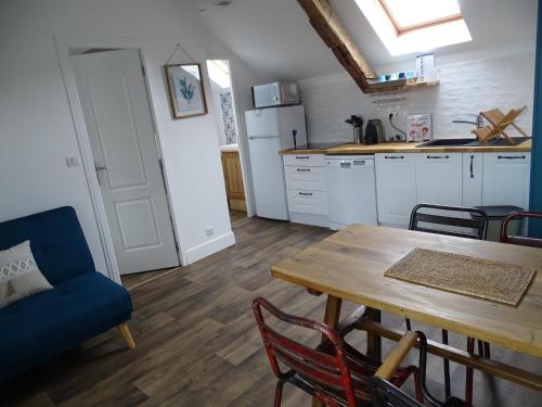 une cuisine avec une table et un canapé bleu dans l'établissement L'ailly, à Saint-Valery-en-Caux