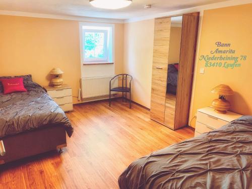 1 Schlafzimmer mit 2 Betten und Holzboden in der Unterkunft Ban Amarita in Laufen