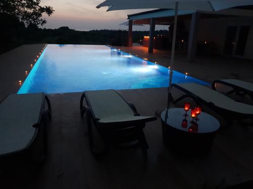 a swimming pool with a table and chairs and an umbrella at Villa Absolute privacy in Novigrad Istria