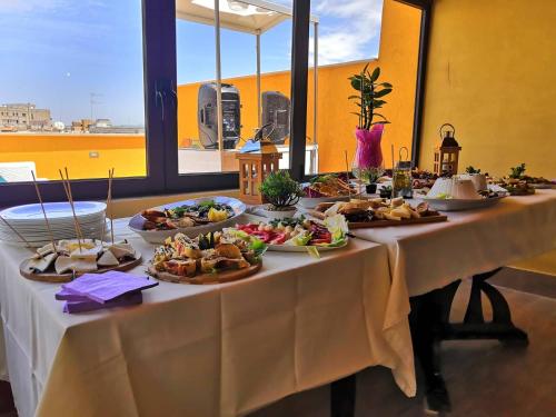 una mesa larga con platos de comida. en Fratelli Clemente Spa and Hotel, en Castelvetrano Selinunte