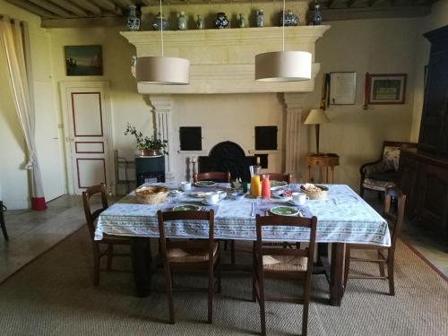 une salle à manger avec une table et des chaises et une cheminée dans l'établissement chez Zaza, à Stigny