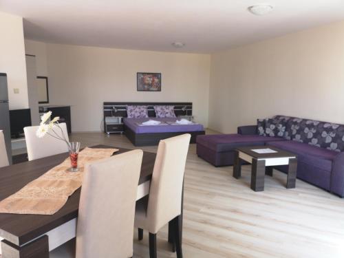 a living room with a table and a couch at Rose Garden Omax Apartments in Sunny Beach