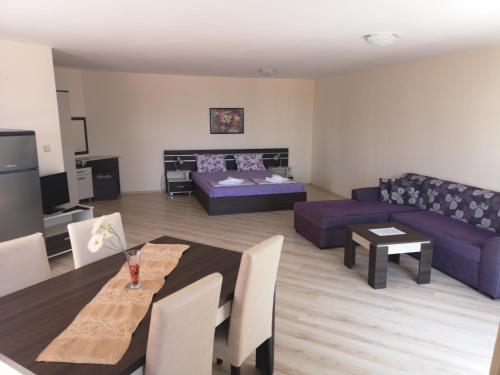 - un salon avec un canapé et une table dans l'établissement Rose Garden Omax Apartments, à Sunny Beach