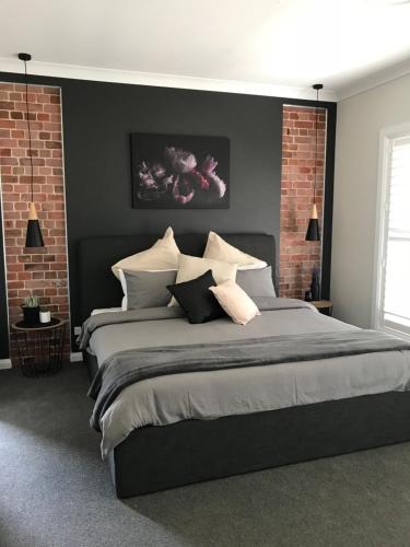 a bedroom with a large bed with black walls at Luxury 2br home with King, 5 star private & close in Bathurst