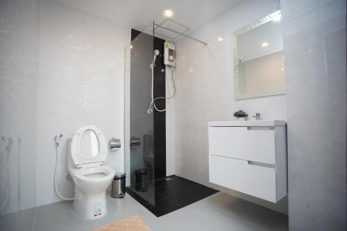 a white bathroom with a toilet and a shower at Tisa Hotel Udonthani in Udon Thani