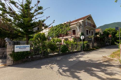 a house with a sign in front of a fence at Villa Popovic in Tivat