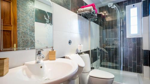 ein Badezimmer mit Waschbecken, Toilette und Dusche in der Unterkunft Villa, Private heated pool and jacuzzi . in Maspalomas