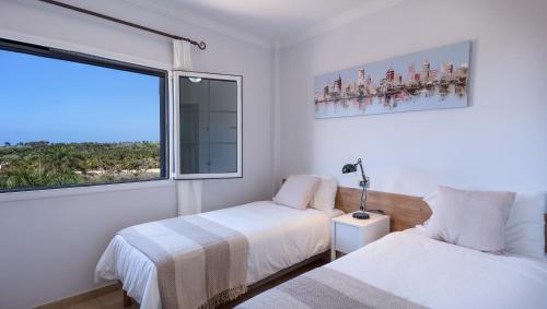 ein Schlafzimmer mit zwei Betten und einem großen Fenster in der Unterkunft Villa, Private heated pool and jacuzzi . in Maspalomas