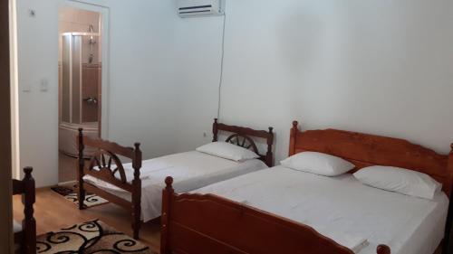 um quarto com 2 camas e um espelho em Guesthouse Sinani em Ulcinj