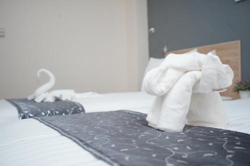 a couple of towels sitting on a bed at Tisa Hotel Udonthani in Udon Thani