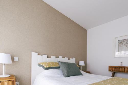 1 dormitorio con cama blanca y almohada en Obidos House with private pool, en Bairro