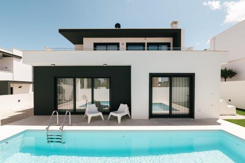 a house with a swimming pool in front of a house at Obidos House with private pool in Bairro