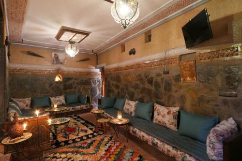 een woonkamer met een bank en een tv bij Toubkal Garden in Imlil